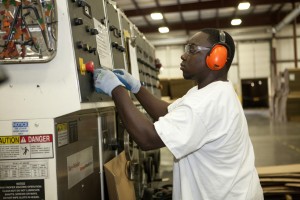 An employee at Signature Packaging and Paper in Jackson, Mo., attends to a machine during a factory tour in 2013. Signature Packaging and Paper, a full service corrugated packaging company, moved to Missouri in 2006 to produce boxes for Proctor and Gamble’s Baby Care Division and have not stopped growing since. Photo: Missouri Partnership)